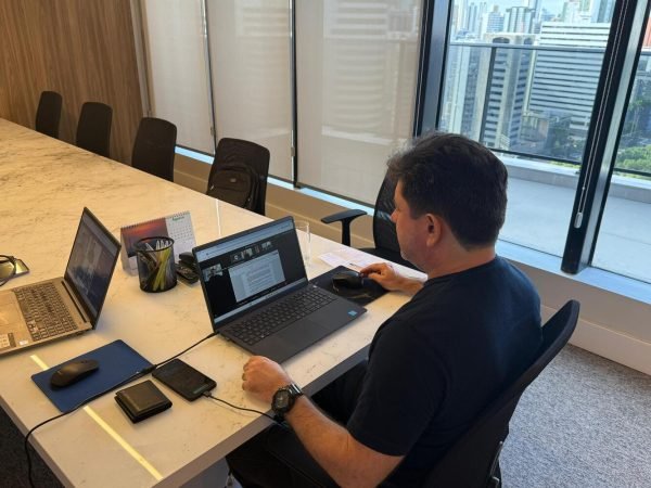 Presidente da AMEPE participa da reunião remota da Diretoria. Ele está sentando na mesa de reunião, olhando para a tela do computador